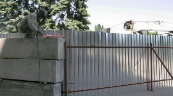 Дом профсоюзов на Куликовом поле огораживают забором. Процесс возведения забора контролирует милиция (фото)