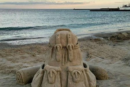 На одном из местных пляжей рядом с кроссовком из песка теперь есть еще и рюкзак (фото)