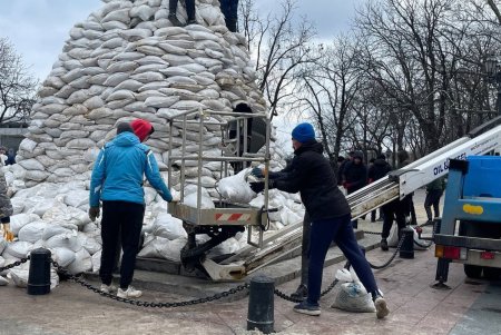 Работники городских служб выстраивают защиту памятника Дюку де Ришелье из мешков с песком (фото)